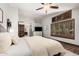 Bright bedroom featuring plantation shutters, wood floors, ceiling fan, and ensuite bath at 2108 E Tecoma Rd, Phoenix, AZ 85048