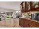 Wooden cabinet with marble countertop, adjoining a dining area and living room with natural light and outdoor view at 2108 E Tecoma Rd, Phoenix, AZ 85048