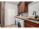 Well-equipped laundry room features granite countertops, custom cabinets, and a modern washer and dryer set at 2108 E Tecoma Rd, Phoenix, AZ 85048
