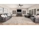 Spacious living room with a stone fireplace, tile floor, ceiling fan and comfortable gray sofas and armchairs at 2108 E Tecoma Rd, Phoenix, AZ 85048