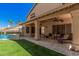Enjoy outdoor relaxation on this covered patio with stone flooring, ceiling fan, and comfortable lounge seating at 2108 E Tecoma Rd, Phoenix, AZ 85048