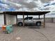 View of an outdoor gravel driveway with a carport and a gray Dodge Ram truck parked under the roof at 2151 S Calle Del Marcos --, Casa Grande, AZ 85194
