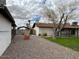 View of a backyard featuring a detached garage, the back of the house, gravel, grass, and mature trees at 2151 S Calle Del Marcos --, Casa Grande, AZ 85194