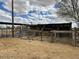View of outdoor horse stalls on a sandy horse property with a partially cloudy sky in the background at 2151 S Calle Del Marcos --, Casa Grande, AZ 85194