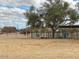 View of horse property featuring a sandy lot and horse stalls with mature trees in the background at 2151 S Calle Del Marcos --, Casa Grande, AZ 85194