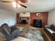 Cozy living room with a brick fireplace, ceiling fan, and comfortable seating arrangement on tile flooring at 2151 S Calle Del Marcos --, Casa Grande, AZ 85194