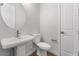 Clean and modern bathroom with a pedestal sink, toilet, and wood look tile flooring at 21539 S 191St Pl, Queen Creek, AZ 85140