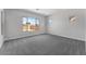 Bright bedroom with large window, neutral gray carpet, and a view of the backyard at 21539 S 191St Pl, Queen Creek, AZ 85140