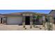 Charming single-story home features a manicured front yard, a two-car garage, and stone architectural accents at 21539 S 191St Pl, Queen Creek, AZ 85140