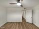 Simple bedroom with wood flooring, a ceiling fan, and an open doorway to the hallway at 2155 W Farmdale Ave # 24, Mesa, AZ 85202