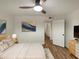 Cozy bedroom featuring a ceiling fan, wood floors, and a modern art piece at 2155 W Farmdale Ave # 24, Mesa, AZ 85202