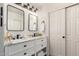Bathroom featuring a dual sink vanity with marble countertops and black hardware with a mirrored sliding door closet at 21860 N 41St St, Phoenix, AZ 85050