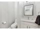 Half bath featuring a toilet, mirror, vanity with cabinets, and quartz countertop at 2251 N 32Nd St # 31, Mesa, AZ 85213