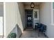 Charming front porch with black door, bench with blue pillows and hanging light fixture at 22752 E Arroyo Verde Dr, Queen Creek, AZ 85142