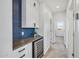 Hallway featuring built-in cabinets, countertop space, mini-fridge, and stylish blue accent wall at 22752 E Arroyo Verde Dr, Queen Creek, AZ 85142
