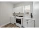 Bright laundry room with white washer and dryer, ample cabinet space, and a window offering natural light at 22752 E Arroyo Verde Dr, Queen Creek, AZ 85142