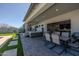 This covered patio has a hot tub, outdoor dining set, and lush artificial turf at 22752 E Arroyo Verde Dr, Queen Creek, AZ 85142