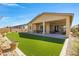 Manicured backyard with artificial turf, covered patio, and desert landscaping at 24738 N 175Th Ave, Surprise, AZ 85387