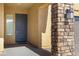 Inviting covered entry featuring a stone column and paneled front door at 24738 N 175Th Ave, Surprise, AZ 85387