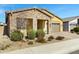 Charming single-story home showcasing a stone facade, desert landscaping, and a two-car garage at 24738 N 175Th Ave, Surprise, AZ 85387