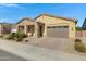 Inviting exterior view of a single-story home with stone accents, a two-car garage, and landscaped front yard at 24738 N 175Th Ave, Surprise, AZ 85387