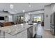 Open kitchen flows into the living and dining areas, with an island featuring seating and stainless steel appliances at 24738 N 175Th Ave, Surprise, AZ 85387