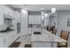 Stylish kitchen with white cabinets, granite countertops, stainless steel appliances and an island with seating at 24738 N 175Th Ave, Surprise, AZ 85387