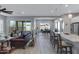 Open concept living space with wood-look tile, a leather sofa, and a view into the dining area at 24738 N 175Th Ave, Surprise, AZ 85387