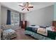 Cozy bedroom with a ceiling fan, window, and comfortable furnishings; perfect for relaxation at 35730 N Pommel Pl, San Tan Valley, AZ 85144