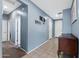 Long hallway featuring light blue walls, neutral flooring, and white doors leading to various rooms at 35730 N Pommel Pl, San Tan Valley, AZ 85144
