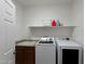 A functional laundry room with a modern washer and dryer, sink, and built-in shelf at 35730 N Pommel Pl, San Tan Valley, AZ 85144