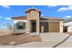 Charming home featuring a stone accent wall, a brown garage door, and desert landscaping at 3746 S 234Th Ln, Buckeye, AZ 85326
