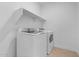 Efficient laundry room featuring modern washer and dryer with overhead shelving at 3746 S 234Th Ln, Buckeye, AZ 85326