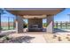 Outdoor lounge area with fireplace and seating between the tennis courts offers residents a cozy retreat at 39801 N Trajen Pl, San Tan Valley, AZ 85140
