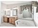Bathroom with double sinks, soaking tub, decorative tile and natural light at 404 W Galvin St, Phoenix, AZ 85086