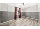 Bedroom with wood-look flooring, dark-patterned wallpaper and natural light from a large window at 404 W Galvin St, Phoenix, AZ 85086