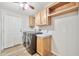 Functional laundry room featuring wood-look flooring, washer, dryer, and ample cabinet space at 404 W Galvin St, Phoenix, AZ 85086