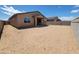 A spacious dirt backyard enclosed by block walls with a covered patio for outdoor relaxation at 4332 W Hannah St, San Tan Valley, AZ 85144