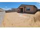 A spacious dirt backyard enclosed by block walls, with a covered patio, ready for customization at 4332 W Hannah St, San Tan Valley, AZ 85144