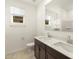 Bathroom featuring double sinks, dark cabinets, a large mirror, and good natural light at 4332 W Hannah St, San Tan Valley, AZ 85144