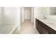 Bright bathroom featuring a shower, bathtub, dual-sink vanity with white countertop, dark cabinet, and tiled floors at 4332 W Hannah St, San Tan Valley, AZ 85144