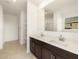 Luxurious primary bath features double vanity with dark cabinets, tile floor, and walk-in shower and closet at 4332 W Hannah St, San Tan Valley, AZ 85144
