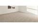 Bright bedroom showcasing neutral-colored carpeting, baseboards, window, and a crisp, clean aesthetic at 4332 W Hannah St, San Tan Valley, AZ 85144