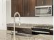Close up of granite countertops, dark cabinets, stainless steel appliances, and a modern faucet at 4332 W Hannah St, San Tan Valley, AZ 85144