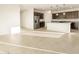Bright living space featuring tile flooring, flowing into a kitchen with dark wood cabinets and stainless steel appliances at 4332 W Hannah St, San Tan Valley, AZ 85144