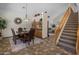 Elegant dining room with staircase, featuring a wooden table, leather chairs, and stylish light fixture at 45583 W Sheridan W Rd, Maricopa, AZ 85139