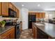 Well-equipped kitchen with modern black appliances, wooden cabinets, and a sink, offering functionality at 45583 W Sheridan W Rd, Maricopa, AZ 85139