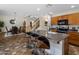 Modern kitchen island with bar stools, wooden cabinets, and dining area, seamlessly connecting living spaces at 45583 W Sheridan W Rd, Maricopa, AZ 85139