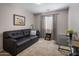 Cozy living room featuring a dark leather sofa and carpet flooring at 45583 W Sheridan W Rd, Maricopa, AZ 85139