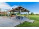 A covered picnic area with tables beside a green grass area and playground at 45583 W Sheridan W Rd, Maricopa, AZ 85139
